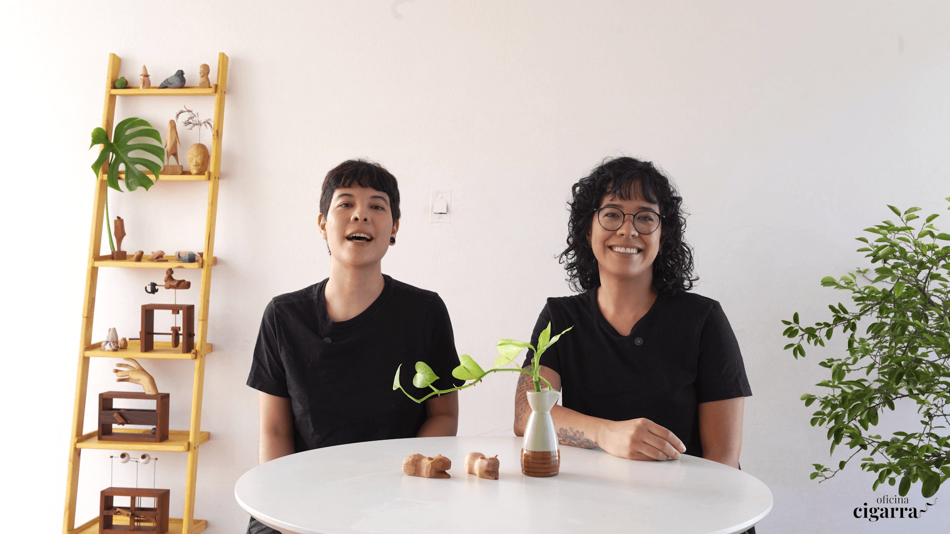 Mayra e Simone, mentoras do curso, com peças entalhadas sobre a mesa