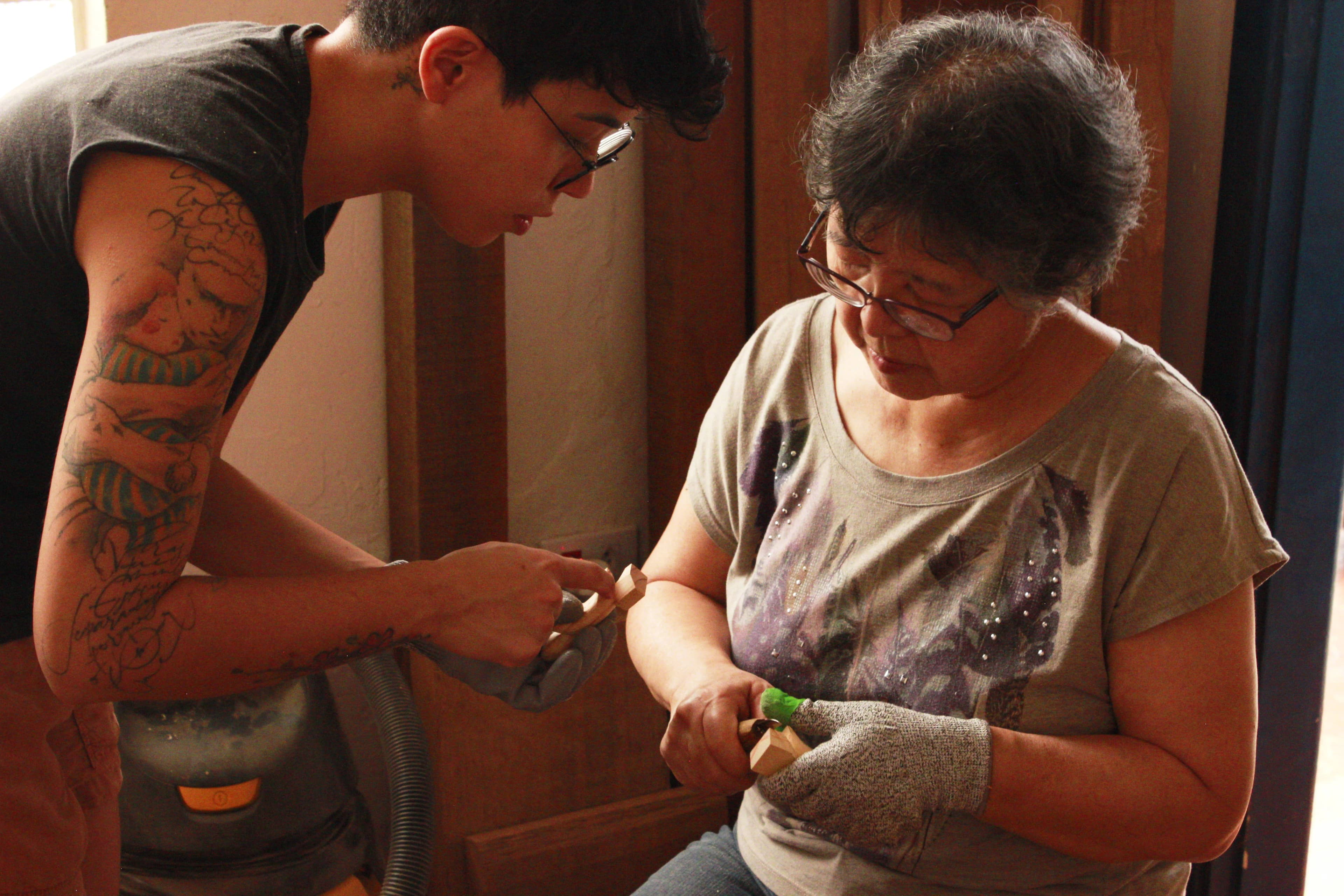 Mãe e criança entalhando madeira juntas em ambiente acolhedor