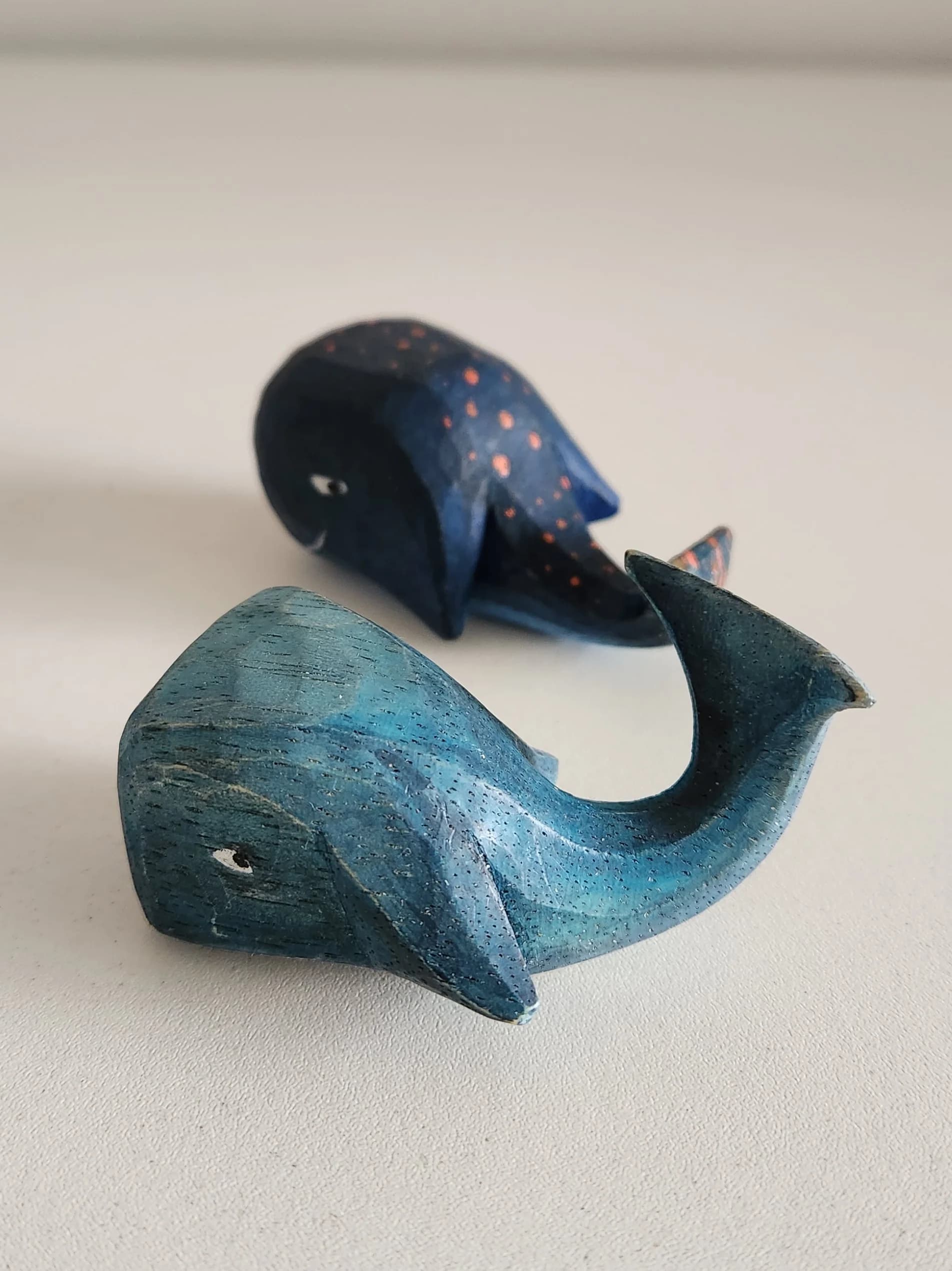 Duas baleias entalhadas em madeira, pintadas de azul