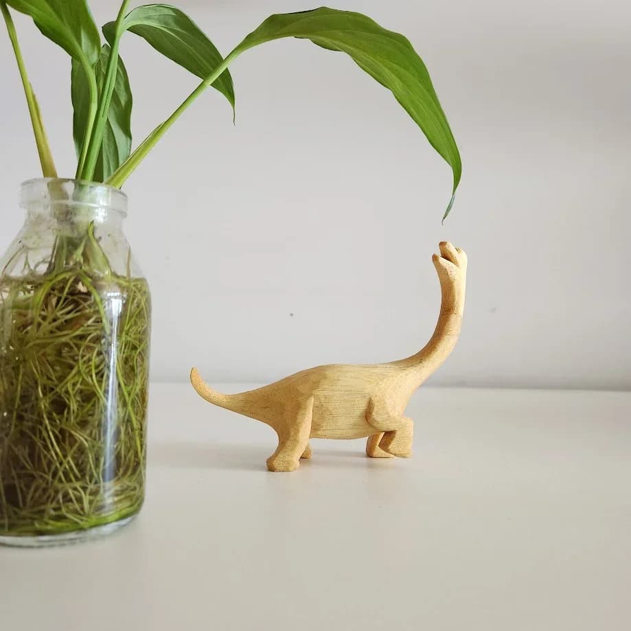 Dinossauro entalhado em madeira natural