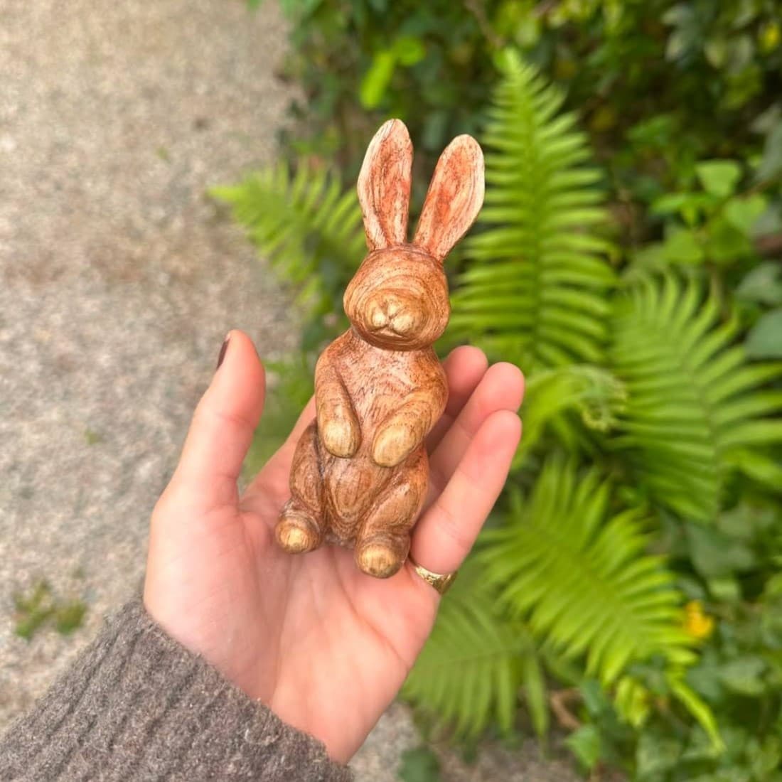 Coelho entalhado por aluno, na palma da mão